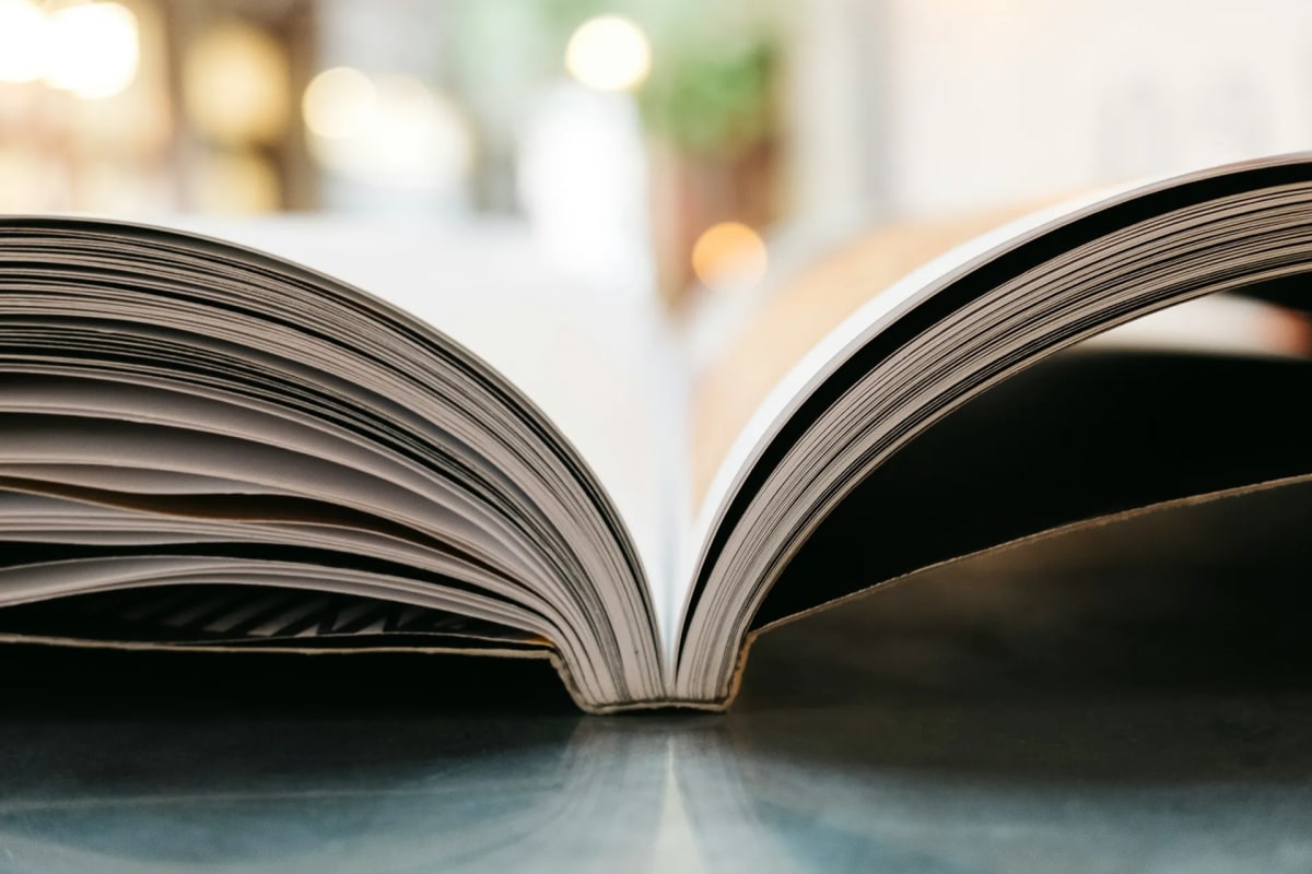 落ち着いた照明の下、男性が読書に没頭し脳を活性化させている。ページをめくる指先に集中する姿は、日常の喧騒から離れてストレス軽減する心の健康効果を示唆する。